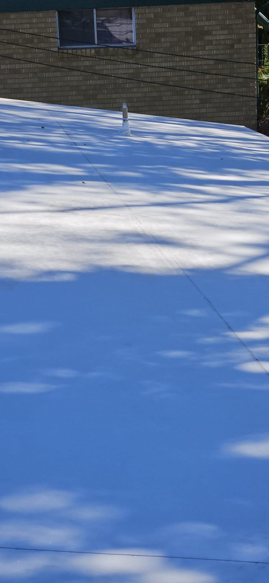 A worker uses a sewer gas sniffer near an open manhole, ensuring safety during sewer cleaning in Long Island. The device displays a reading, highlighting the benefit of detecting dangerous gases before they cause harm.