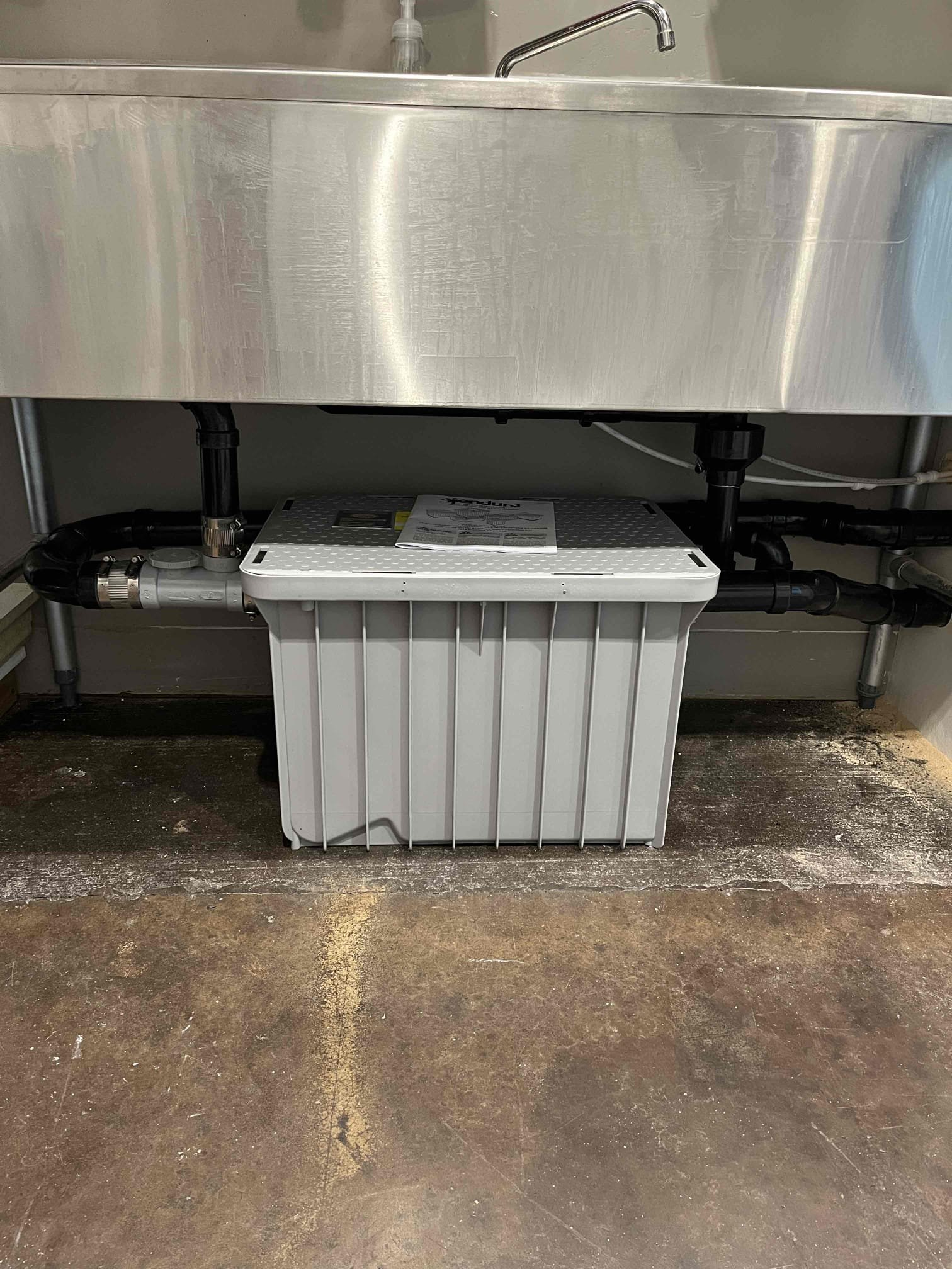 Image of a technician using a gas sniffer in a bright, clean commercial space, subtly hinting at effective smoke odor removal. The professional equipment and orderly environment visually communicate reliability and affordability.