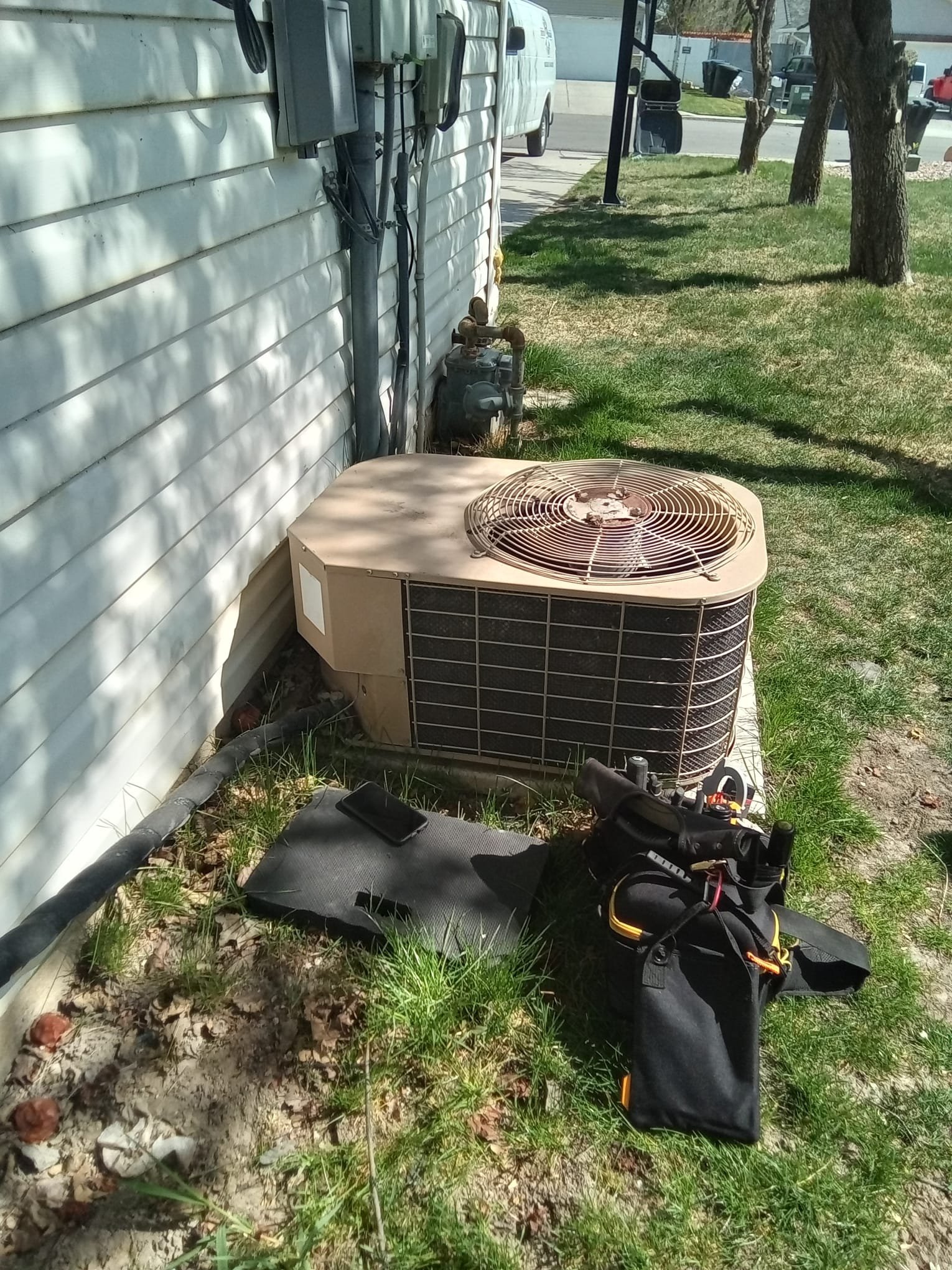 Residential backflow valve installed near a mini-split outside unit. Clean, professional plumbing work by HVAC contractor ensures efficient and safe operation, protecting the home's water supply.