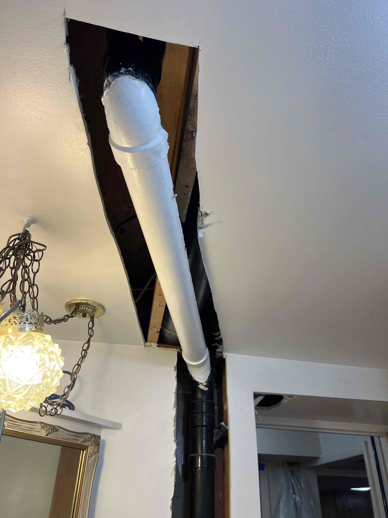 Basement ceiling showing water damage with visible mold growth around a ceiling vent, indicating a need for water damage repair and mold remediation services. Likely related to previous water damage incidents.