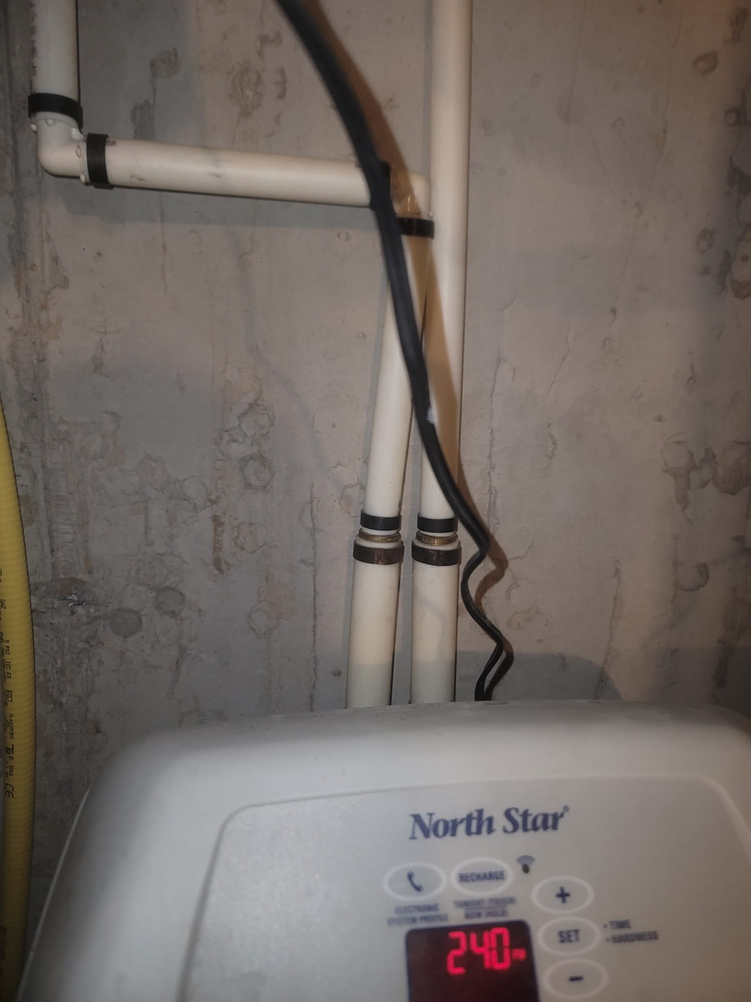 Visual comparison of pipes: one clogged with scale from hard water (untreated), the other clean after water conditioning. A water softener is highlighted, emphasizing calcium removal and the importance of regular water softener tune-ups for maintaining optimal performance and preventing scale buildup.