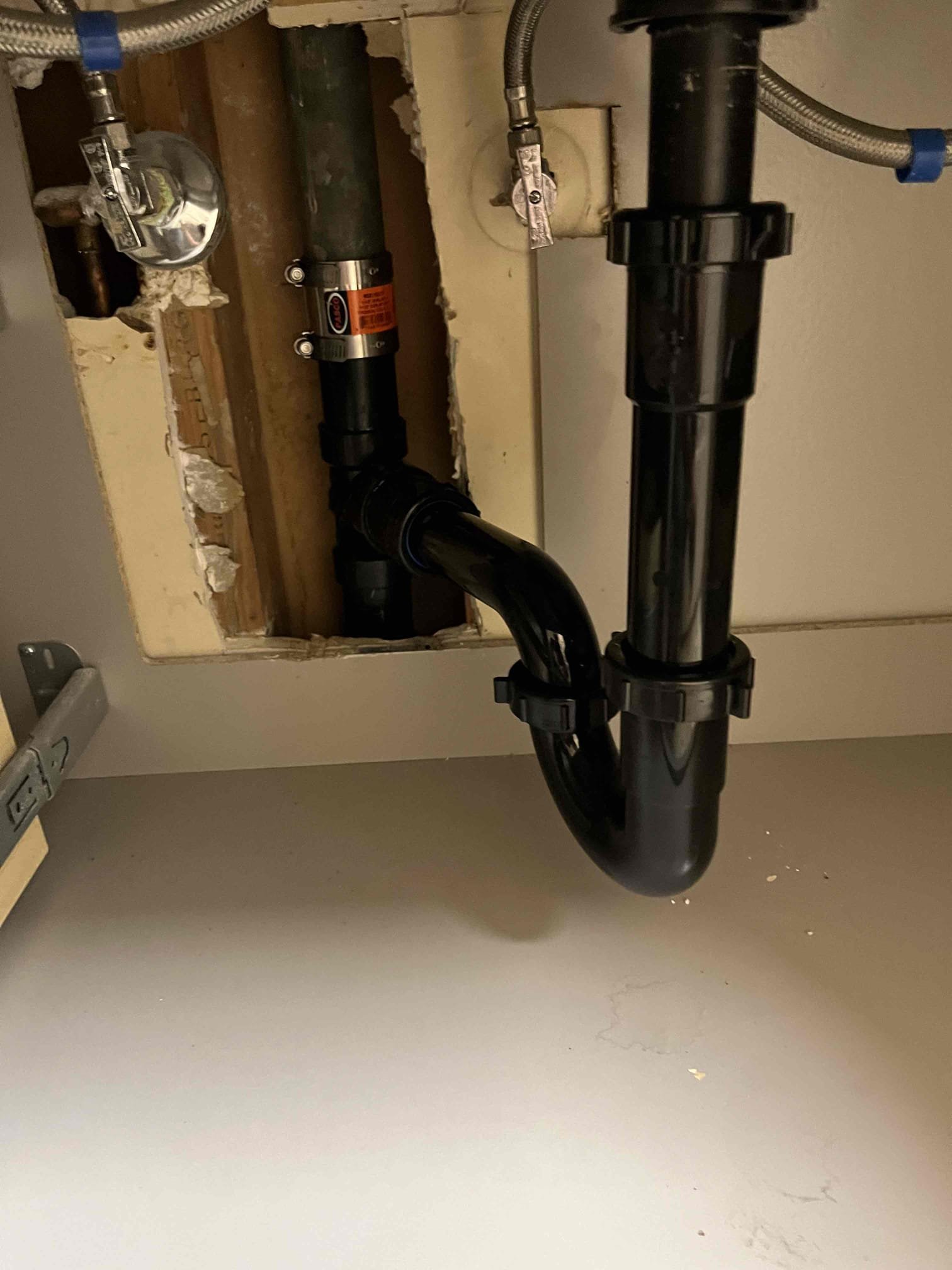 Image of a clean, well-organized plumbing workspace with a plumber using a plumbing snake. In the background, there's a modern HVAC unit, implying comprehensive heating and cooling services. The focus is on efficiency and professional equipment, highlighting the benefits of using experienced professionals.