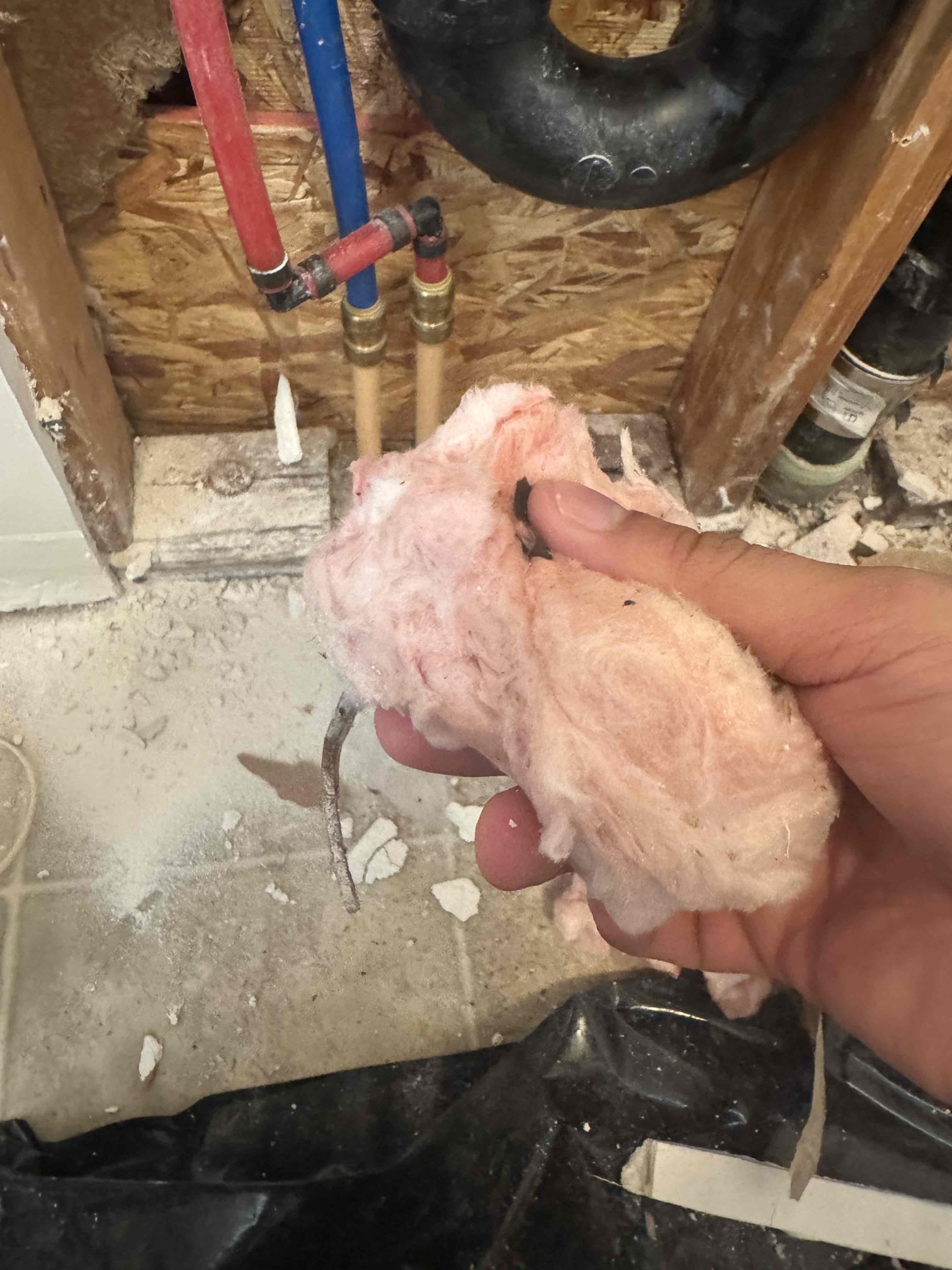 Image of a home interior, half showcasing water-damaged belongings meticulously organized for content restoration, the other half displaying newly installed drywall and flooring, illustrating comprehensive residential restoration services.