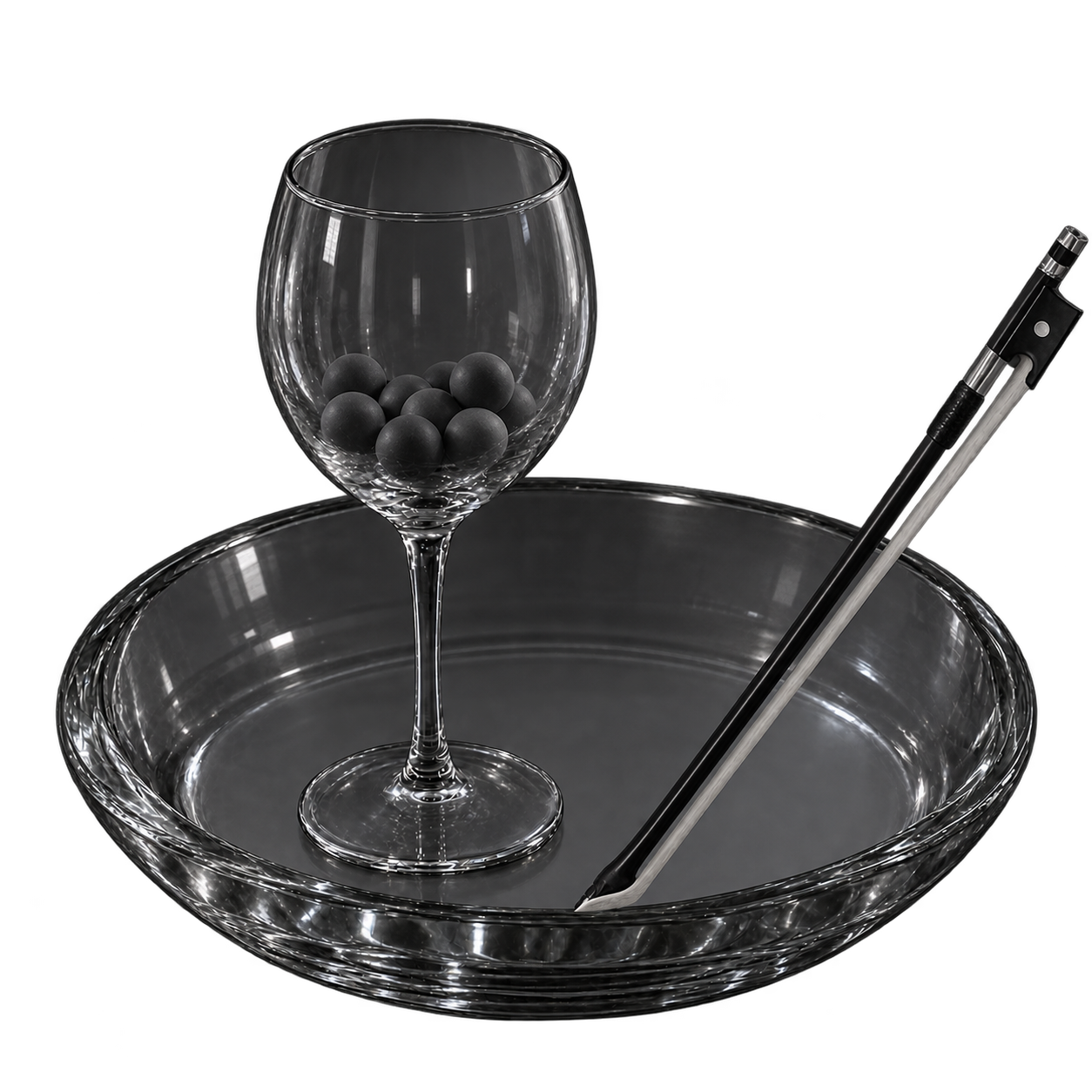 Resonant glass bowl with violin bow and stemmed glass containing miniature rubber balls