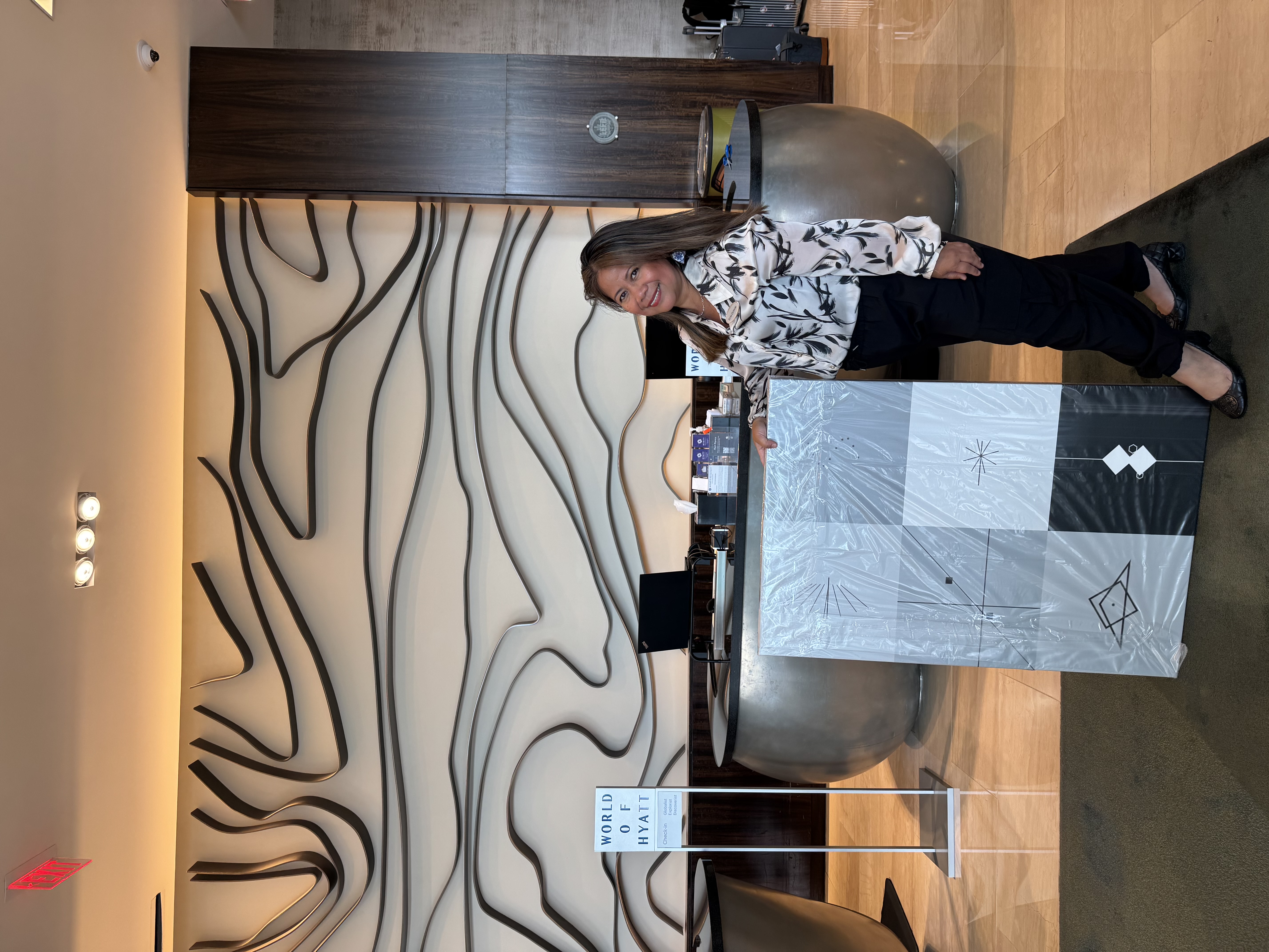 A happy Hyatt hotel manager with her newly received custom monomelist wall art