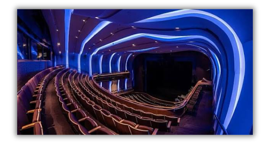Theater seating beneath curved architectural lighting.