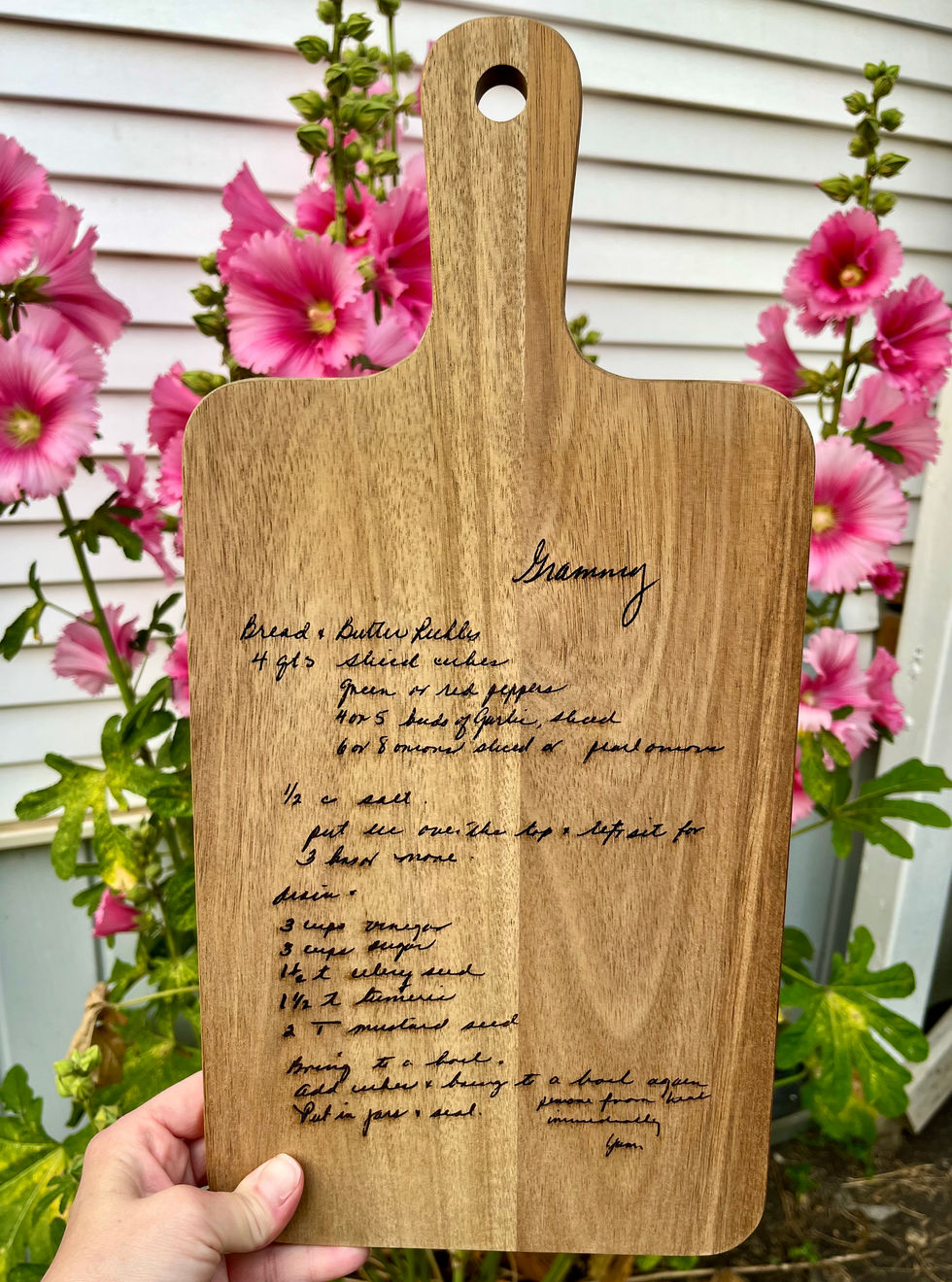 Wooden cutting board with a handle and a family member's recipe engraved for a special gift.