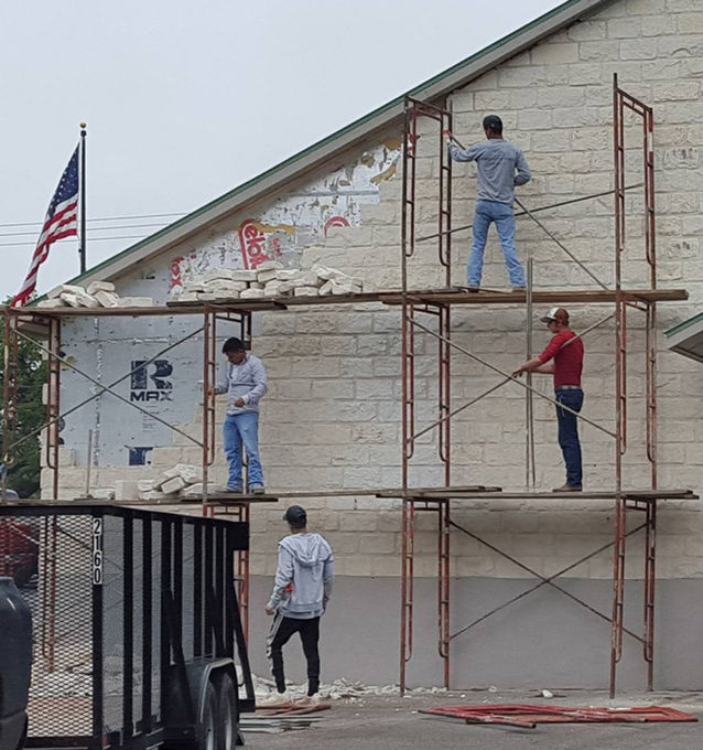 Masons build the rock wall facing Highway 281 as the Blanco Library grows in size to match the growth in its community.