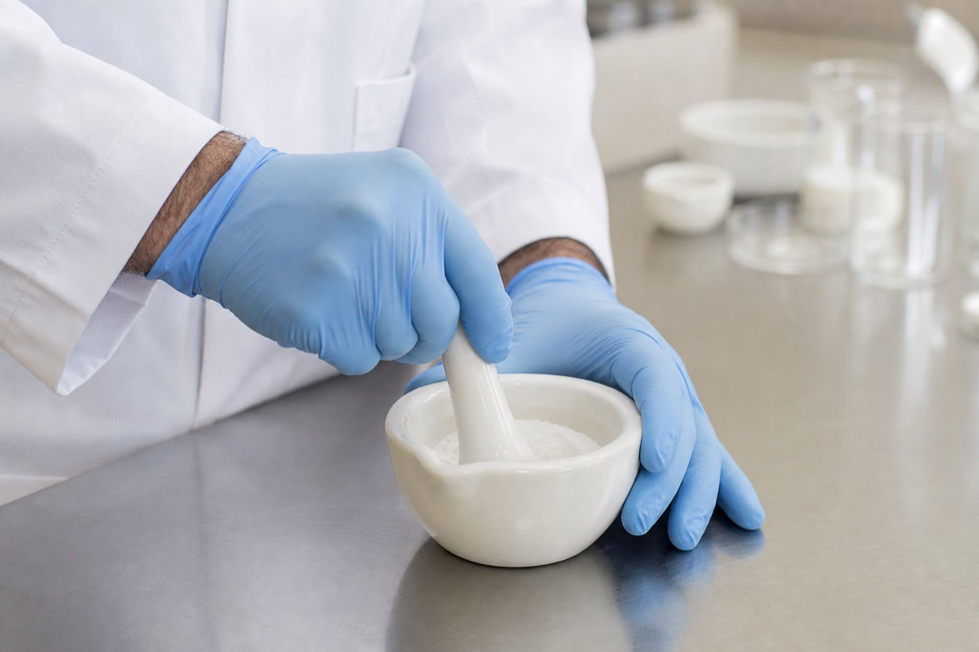 Hands at work with a mortar and pestle at the compounding bench