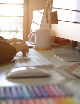 Graphic designer at desk typing