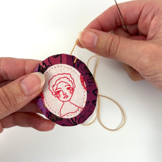 Whip stitch embroidery around fussy cut brooch edge