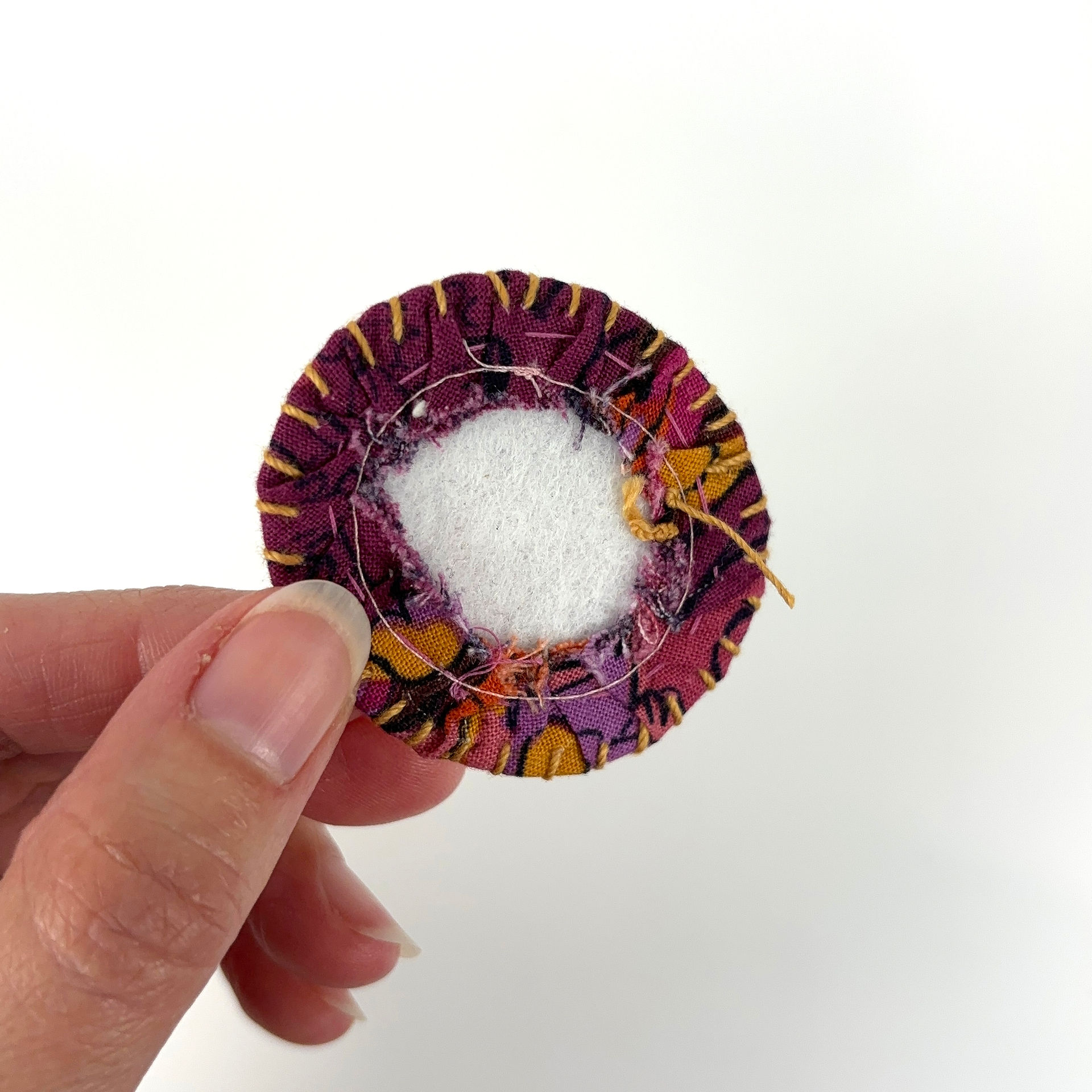Hand stitching embroidery around fussy cut brooch edge