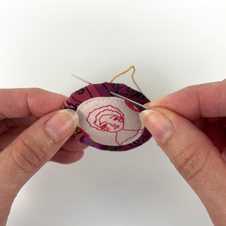 Whip stitch embroidery around fussy cut brooch edge