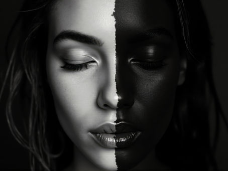 Black-and-white portrait of a face divided between light and dark skin tones, representing race, humanity, and the meanings society assigns to skin color.