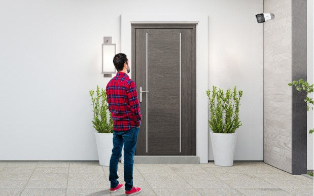 Man looking at a CCTV camera at the front door