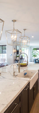 Exposed wood beams, custom reclaimed wood cabinets, and a farmhouse sink create a warm, inviting space. The new open layout and updated tile flooring bring modern functionality to this rustic kitchen.