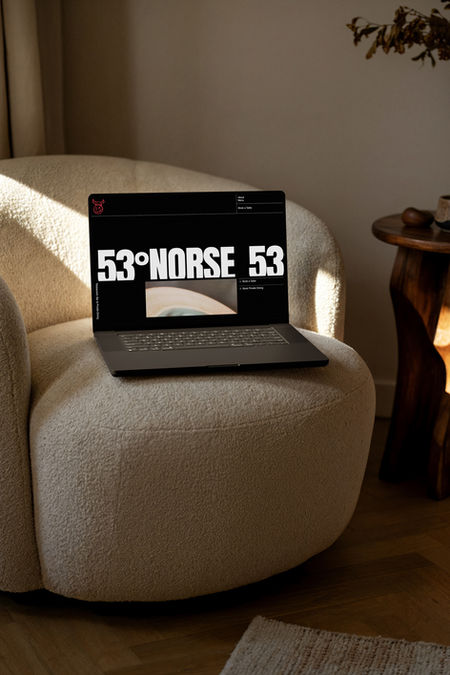 53 Degrees Norse website homepage on a macbook, on sofa mockup