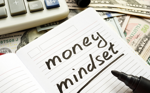 a notebook that reads money mindset surrounded by a calculator and cash