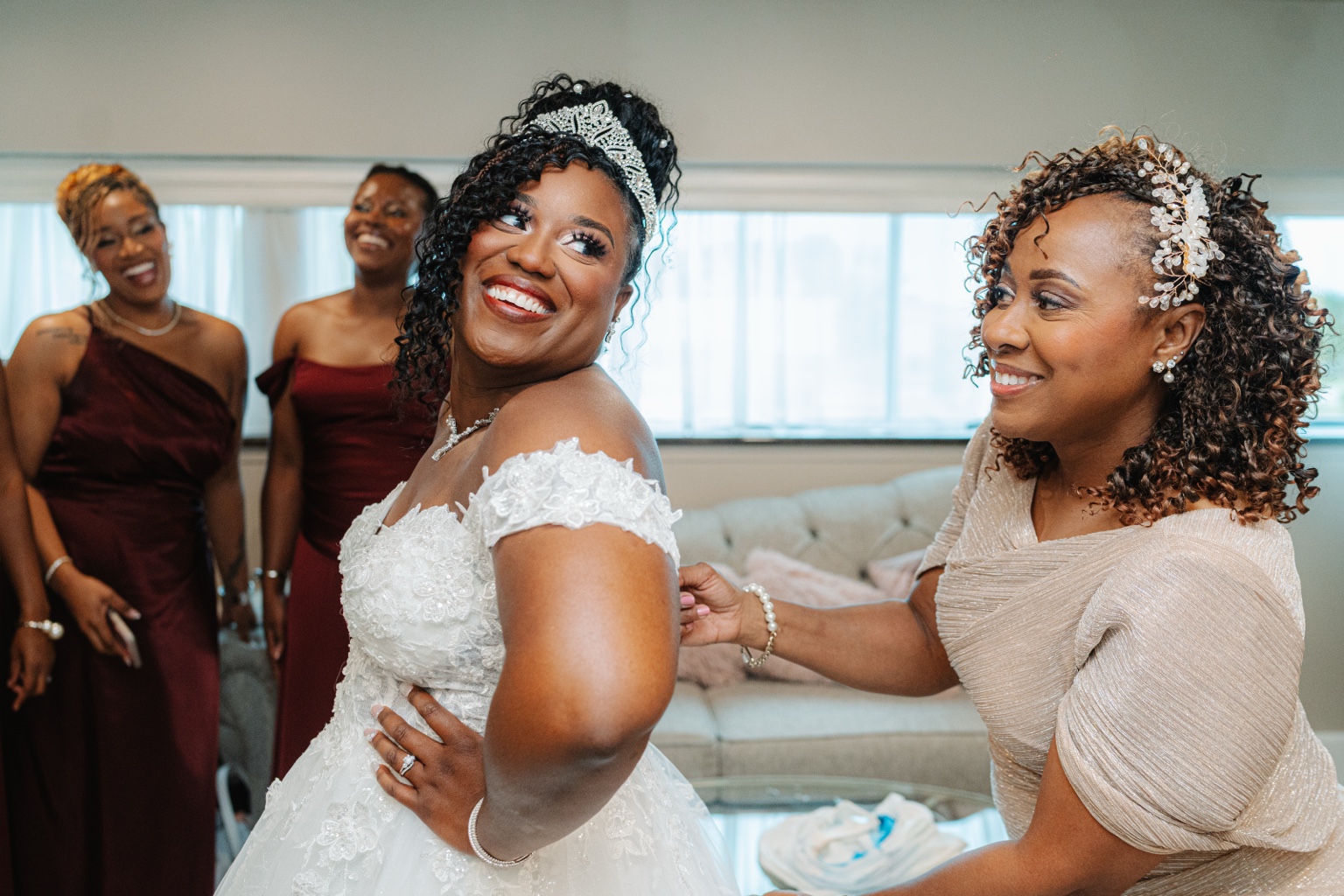 Ramarra smiling as her mother helps with her wedding gown.