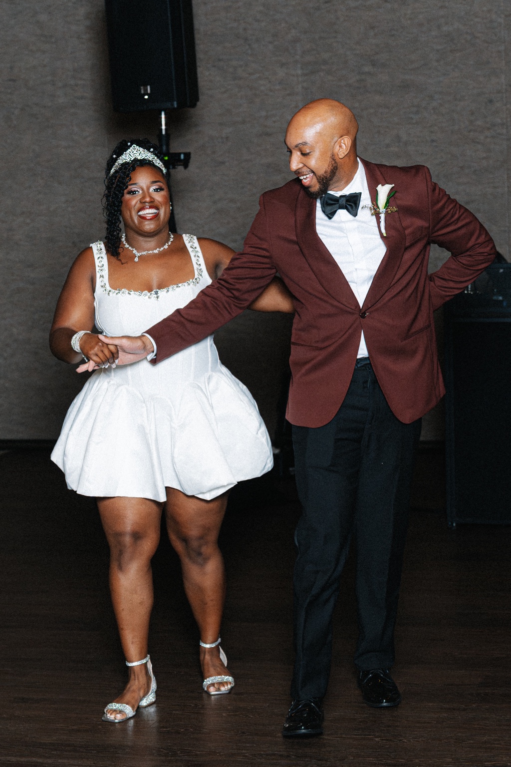 Ramarra in her white reception mini dress dancing beside Evan.