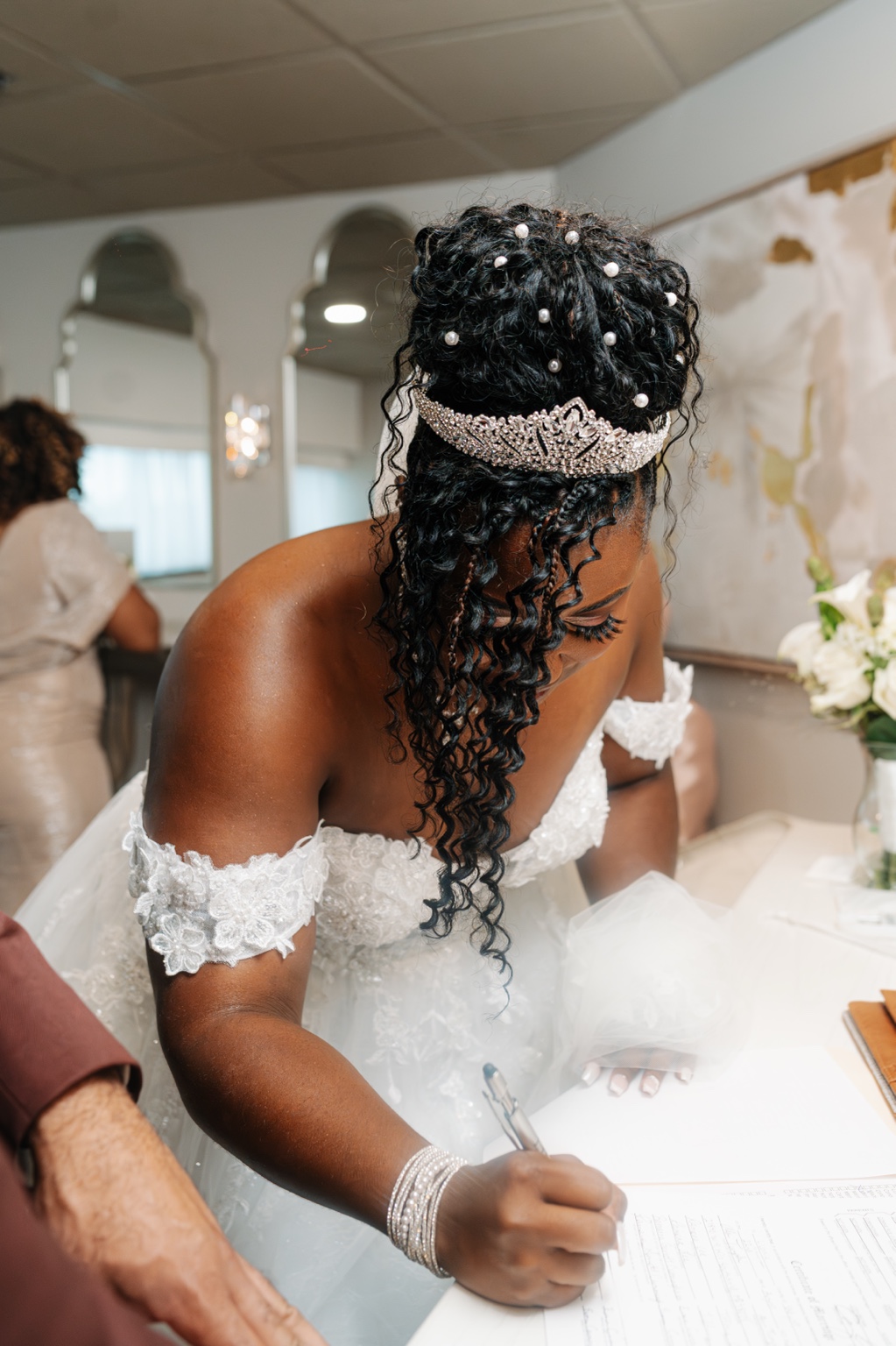 Ramarra signing a document in her wedding gown.