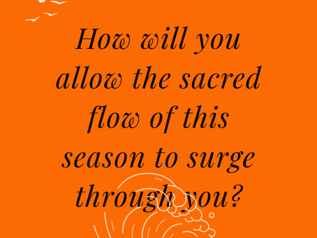 Orange background with flowing script text: "How will you allow the sacred flow of this season to surge through you?" Illustrated white birds in top left corner and waves on bottom center that overlap the text slightly.