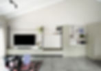 Modern living room with minimalist TV unit and shelving.