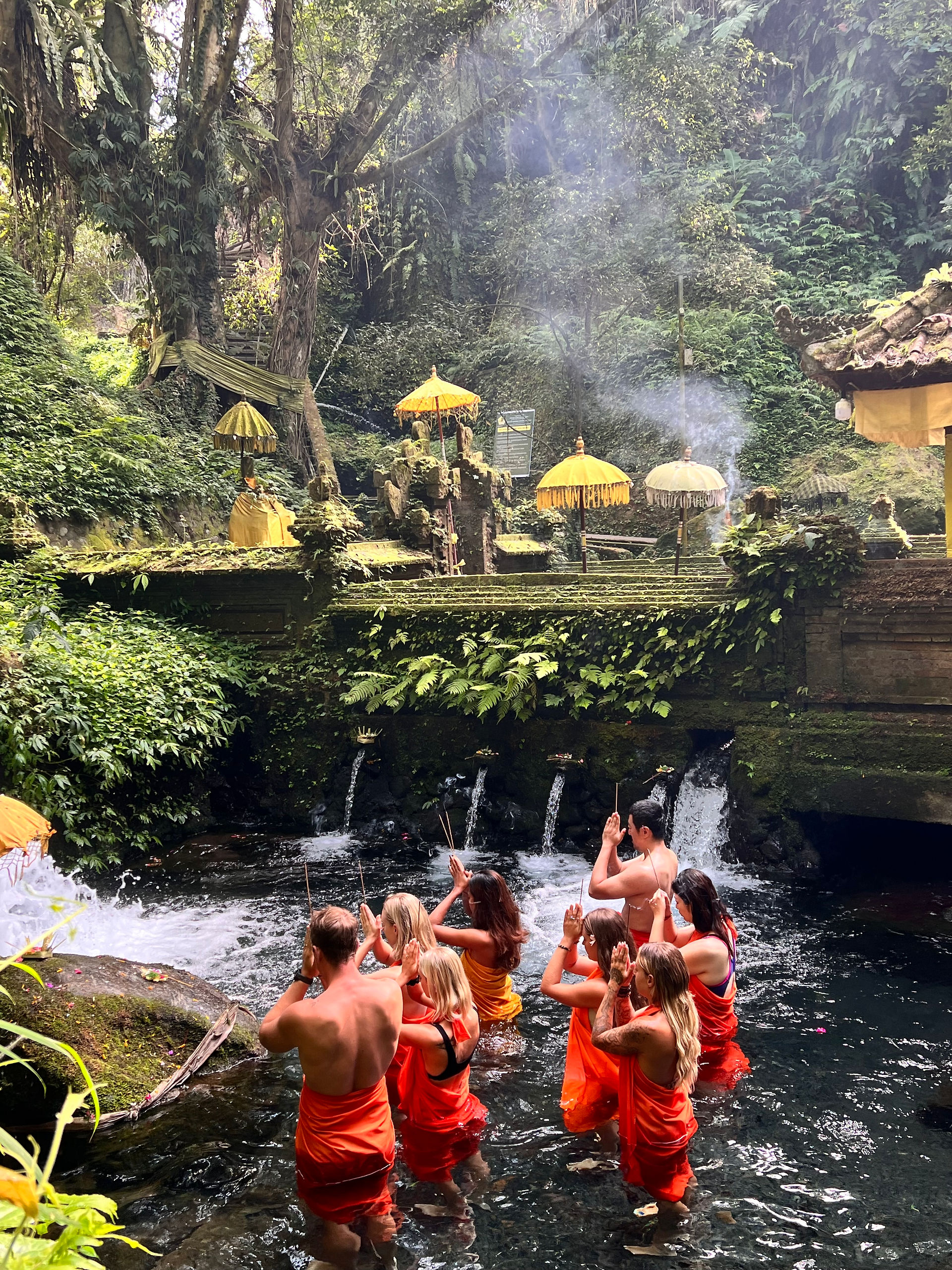 group of people in a forest participating in a Indonesian water ritual 