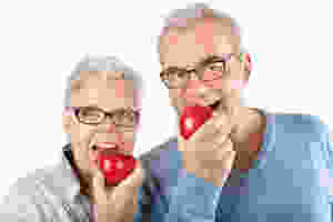 Pareja mayor mordiendo una manzana