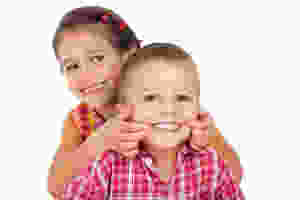 Niños sonriendo sin manhas en los dientes