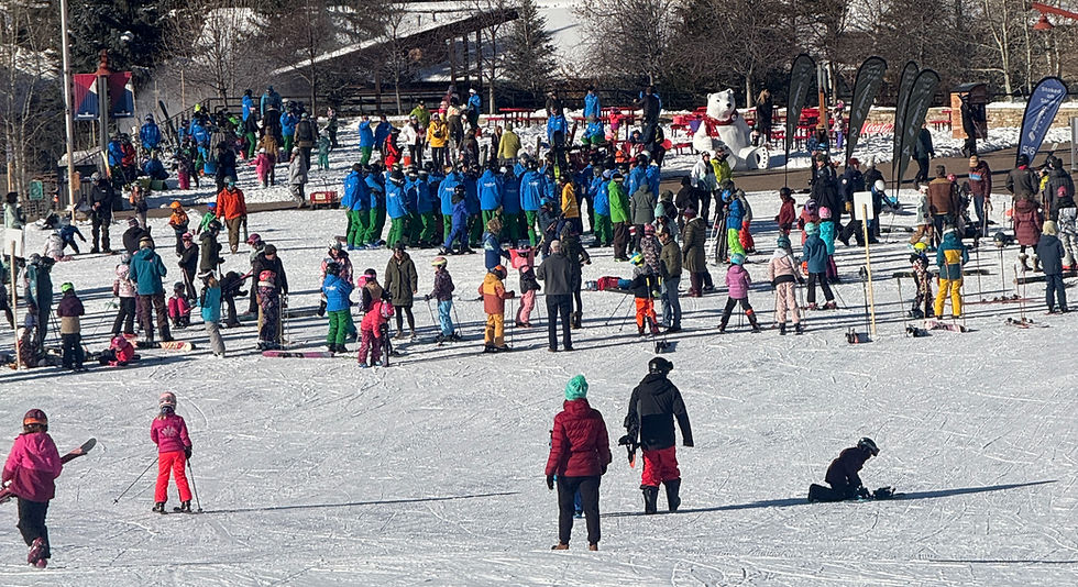 a big crowd of people gathering to send their kids to ski school