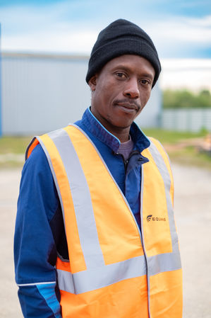 Portrait d'un ouvrier avec un gilet orange.