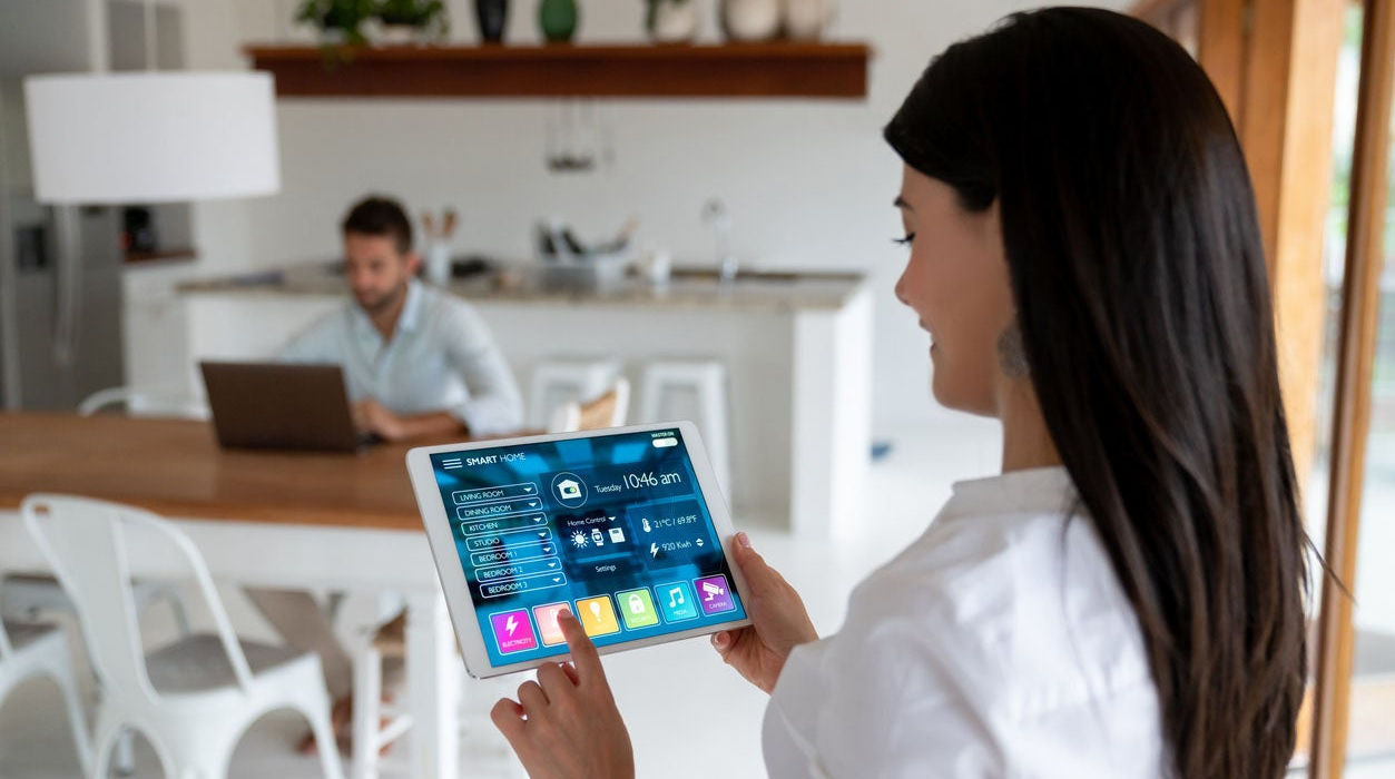 Girl using a tablet to control her smart home showcasing the convenience of Smartology's solutions.
