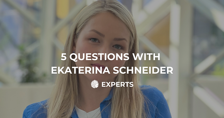 Ein Porträt von Ekaterina Schneider mit der Überschrift „5 QUESTIONS WITH EKATERINA SCHNEIDER“ und dem Label „EXPERTS“. Der Hintergrund zeigt eine moderne Architektur mit viel Glas und Metallstrukturen.