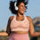 Thumbnail: Joyful plus size woman outdoors wearing head phones and pink Mindful Mandala sports bra.