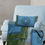 Thumbnail: Blue Mandala throw pillow (mandala side) on a comfy blue chair. Matching blanket on chair, matching tote bag by chair.