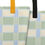 Thumbnail: Zoomed-in view of the green plaid tote bag where the handle attaches to the bag.