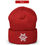 Thumbnail: A red beanie hat. Design features embroidered white snowflake with a white peace sign in the center of the snowflake.