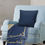 Thumbnail: Sunflower Sunset throw pillow (back side) on a comfy blue chair. A matching Sunflower Sunset throw blanket on chair.