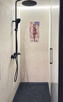 This striking piece presents a surreal, dreamlike figure poised in a richly detailed fantasy setting. The central character — a humanoid form with a Zebra head — wears a black and white striped bodysuit, exuding both mystique and elegance. Surrounded by classical sculptures and a patterned floor reminiscent of ancient mosaics, the figure stands as a guardian of a fantastical realm where mythology and imagination meet.

Above, a soft sky with floating flamingos enhances the ethereal quality of the composition. The scene is at once whimsical and powerful, a statement of bold visual storytelling that fuses fashion, fantasy, and symbolism.

Expertly produced on high-quality ceramic tiles (azulejos), this artwork is designed to withstand humidity, making it an ideal feature for contemporary bathrooms, wellness spaces, or statement walls.