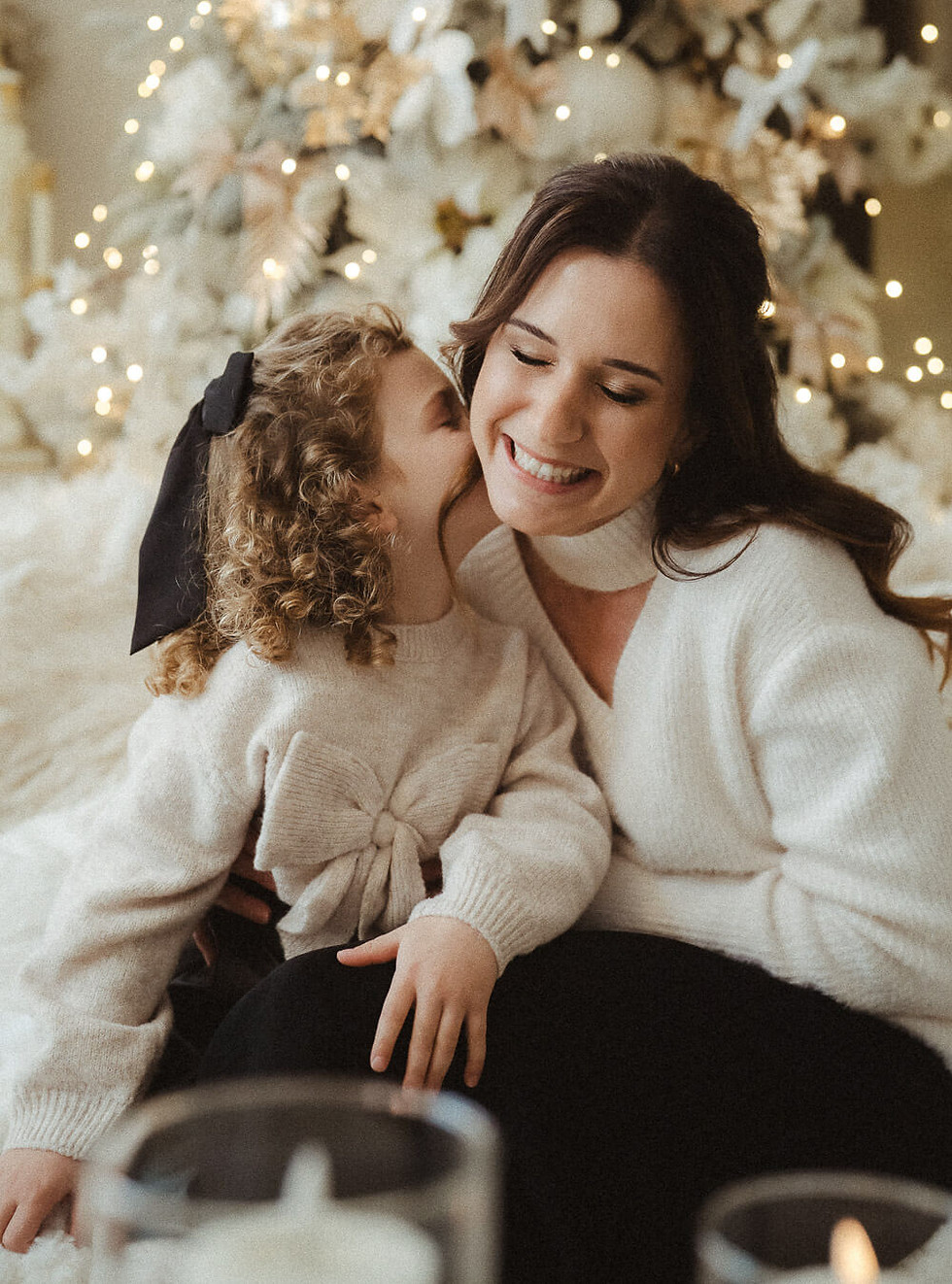 Mutter und Tochter im Weihnachtsambiente, sanftes Licht und warme Farben – liebevolle Szene voller Nähe und Geborgenheit.