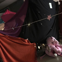 a load of blanket sheet things tied together, some string with glow in the dark stars on it, and a purple unicorn guarding the blanket-fort