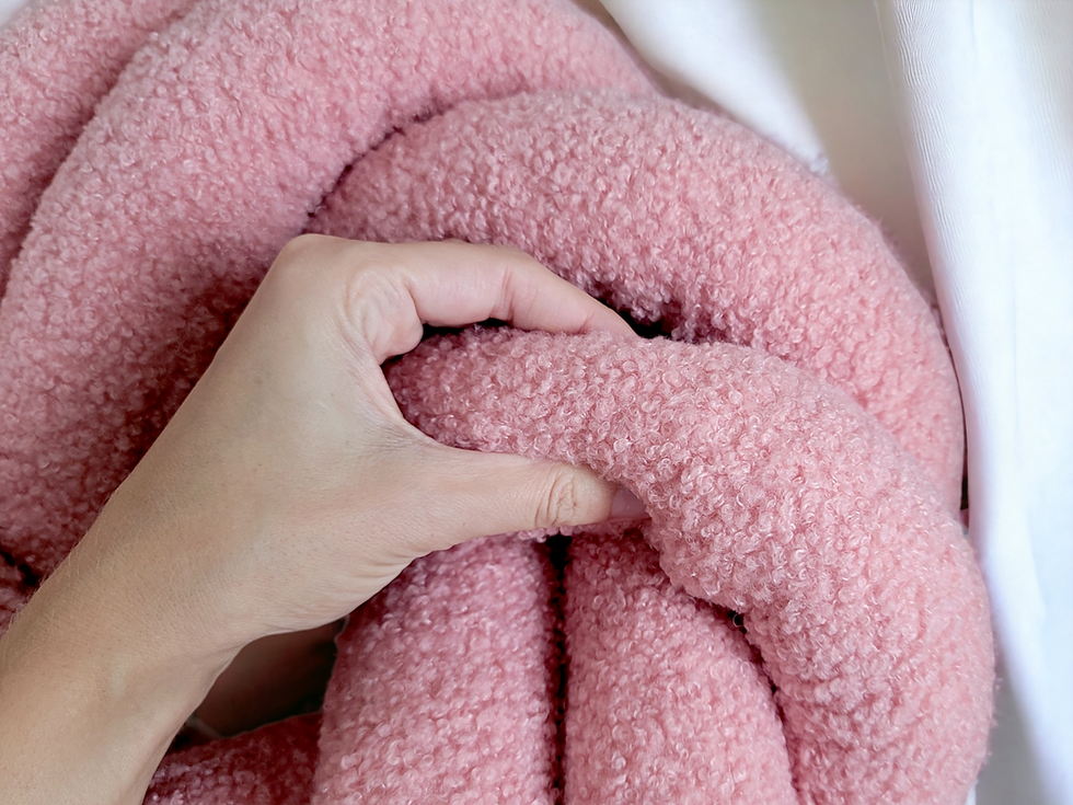 Thumbnail: a person holding textured braided pillow in swirl shape for cozy home chic decor