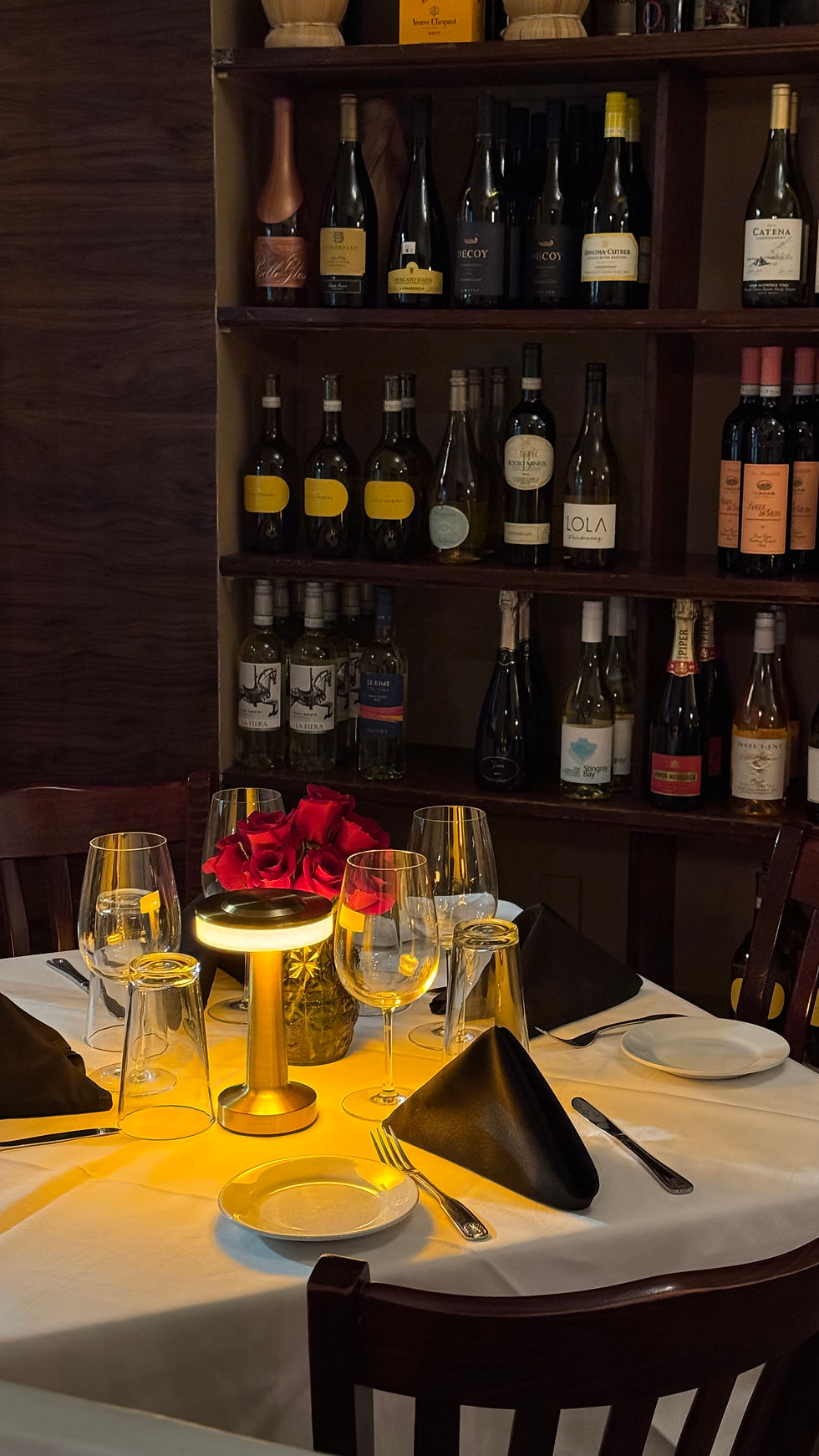 Romantic table setup with wine and roses at Italian restaurant in Miami.