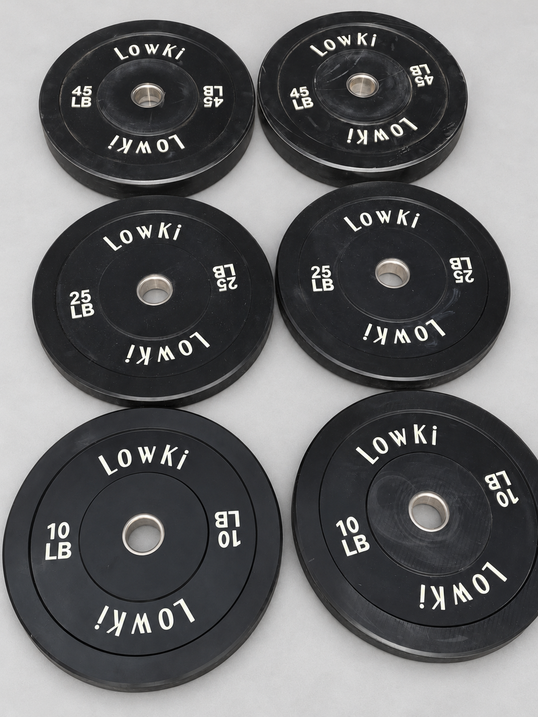 LowKi black bumper plates in 10, 25 and 45 lb pairs on a light gray background
