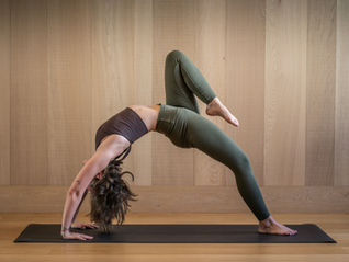 Woman performing a Mat Pilates exercise demonstrating proper form, core control, and body alignment