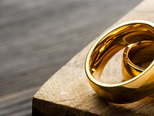 Two golden wedding rings lying together on a wooden table