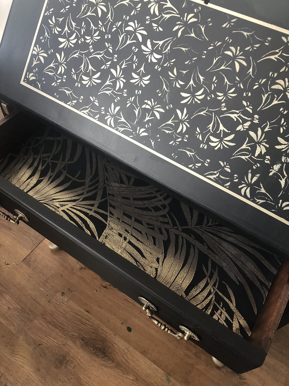 Thumbnail: a view of one of the drawers open a some of the stencil design on the drop down door