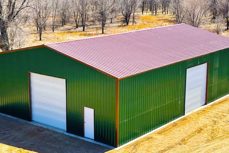 Green commercial metal building with red roof and roll-up door
