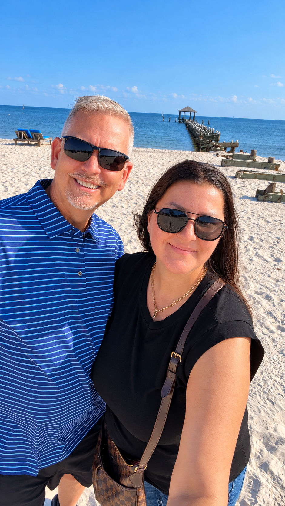 Couple on the beach with a pier on a Gulf Coast day trip from Pensacola